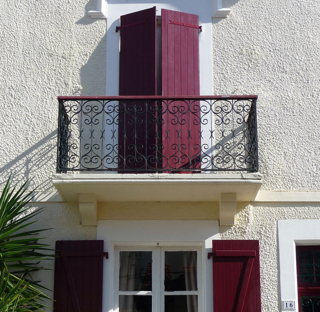 Volets et porte-fenêtre en bois a barres et écharpes, avec pentures à la couleur du volet.