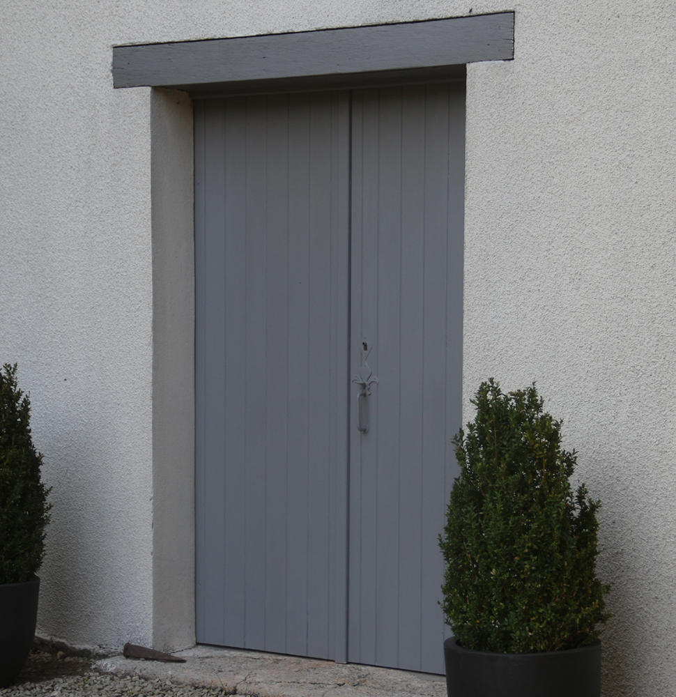Remplacement d'une porte par des panneaux de volets sapin à barres seules, laqués gris